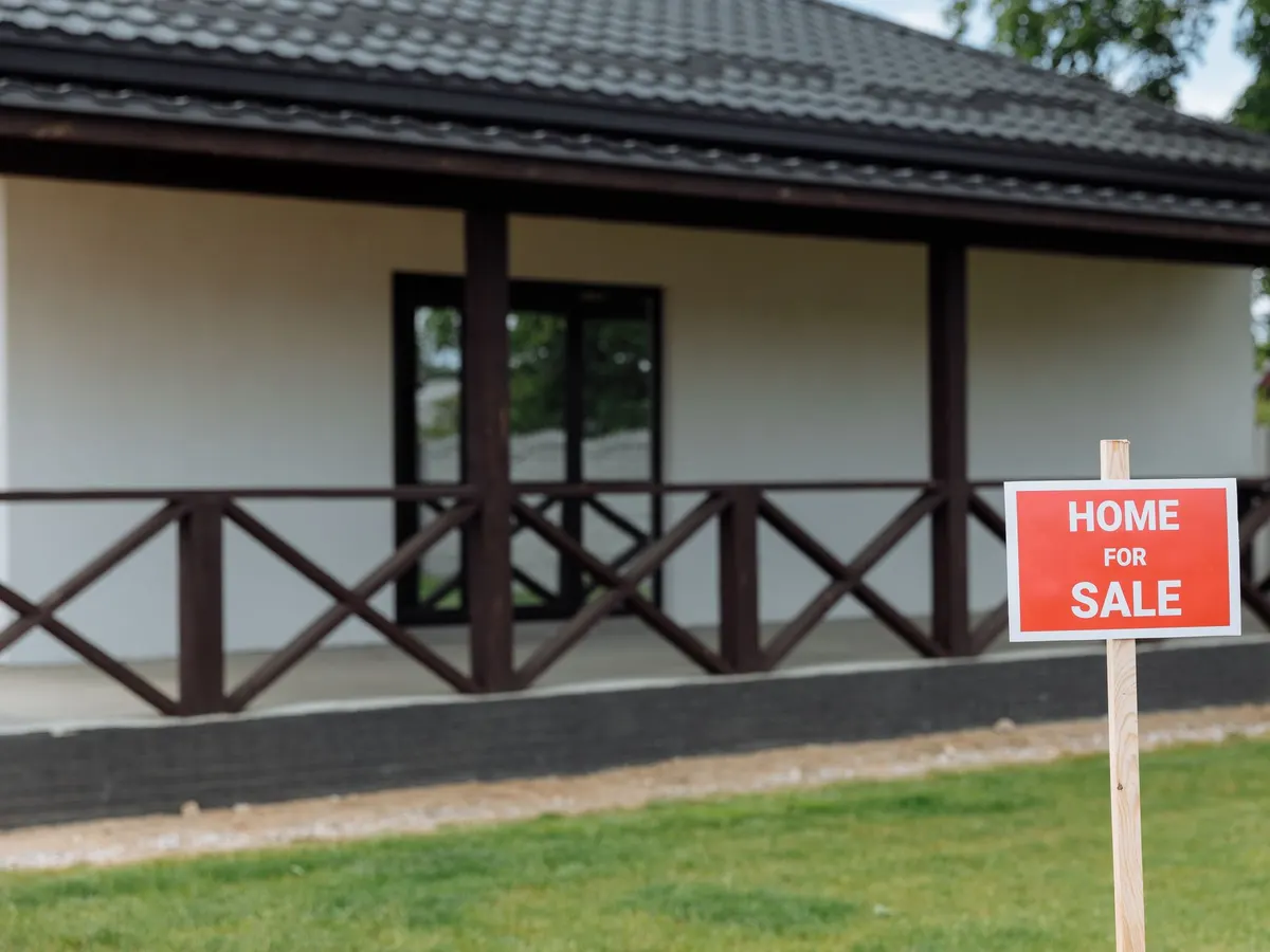 Small stake sign on a lawn in front of a house