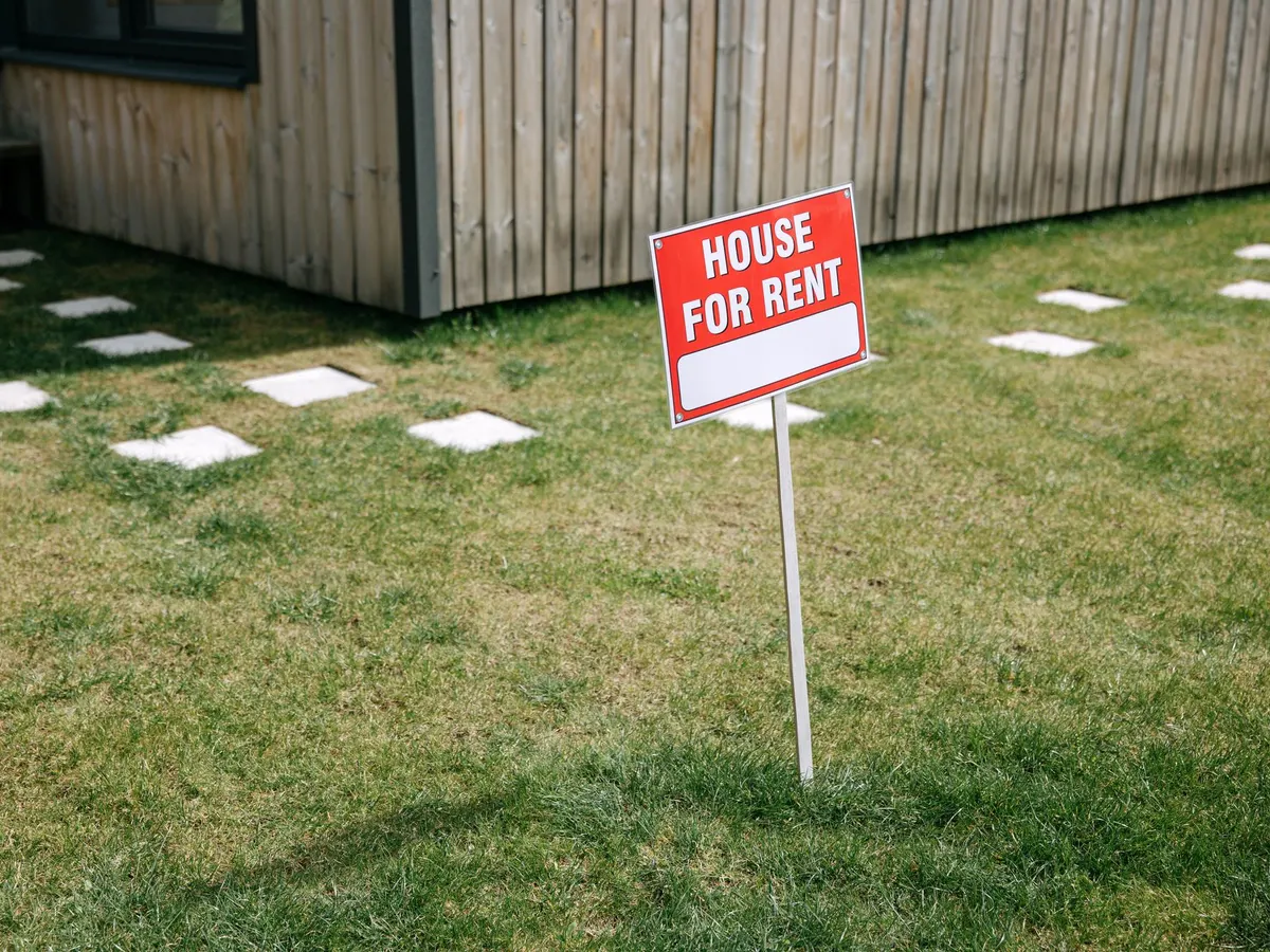 Red stake sign standing on a grassy lawn